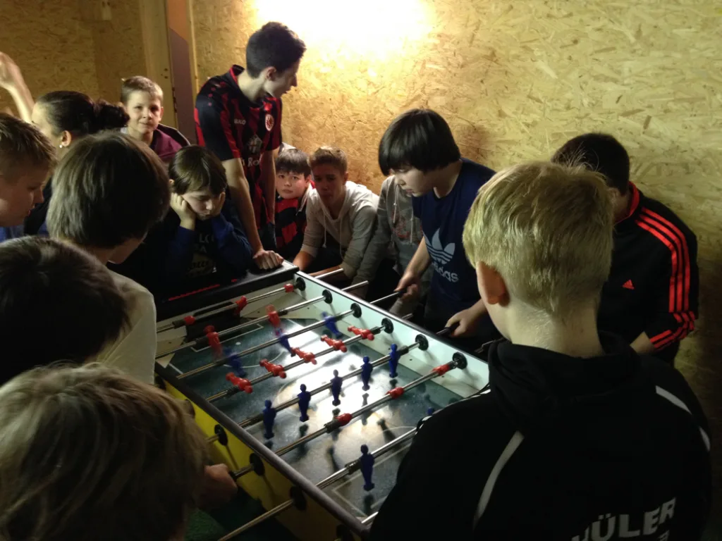 Jugendliche drängen sich um den Tischfußballtisch.